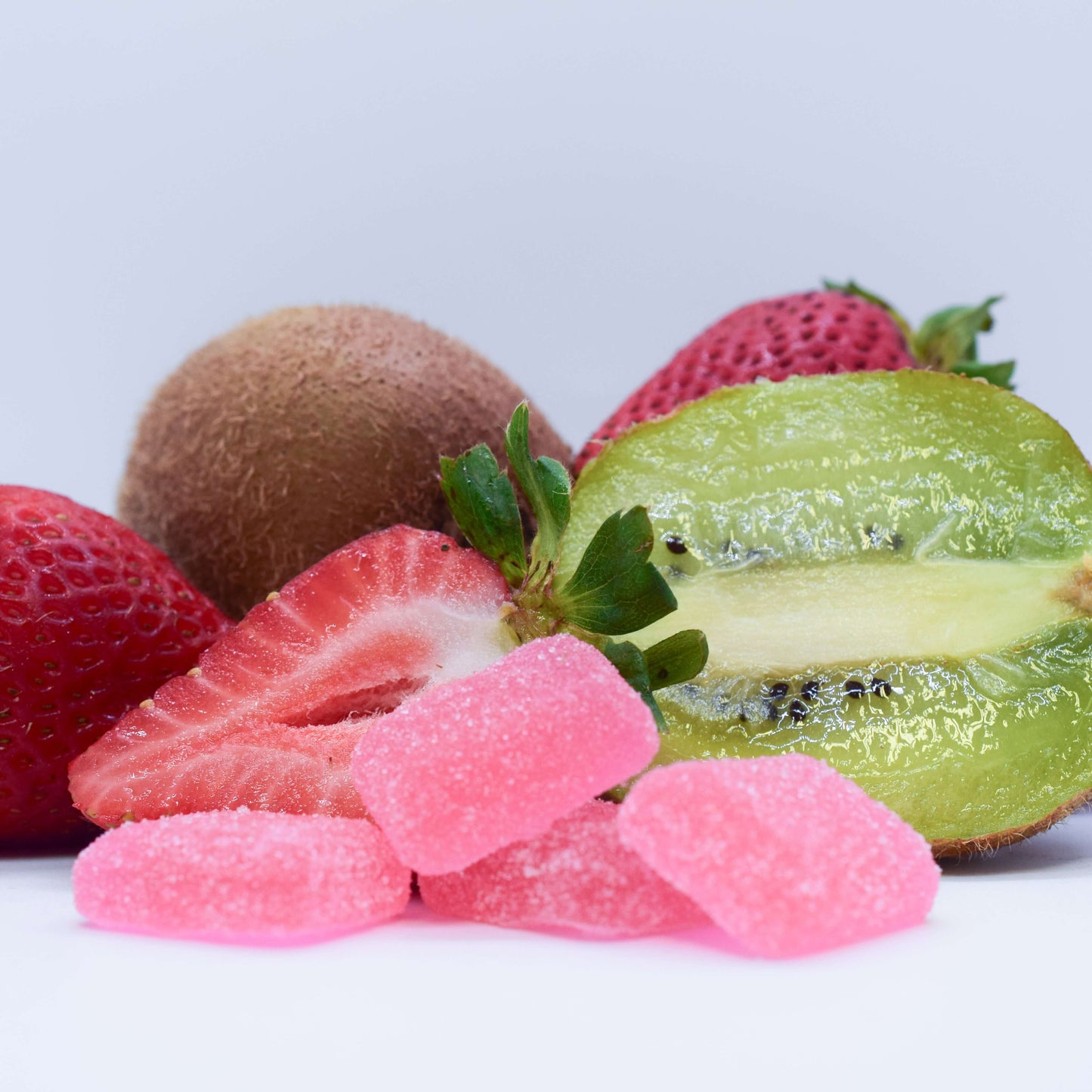 Fruit gummies and strawberries on a white background