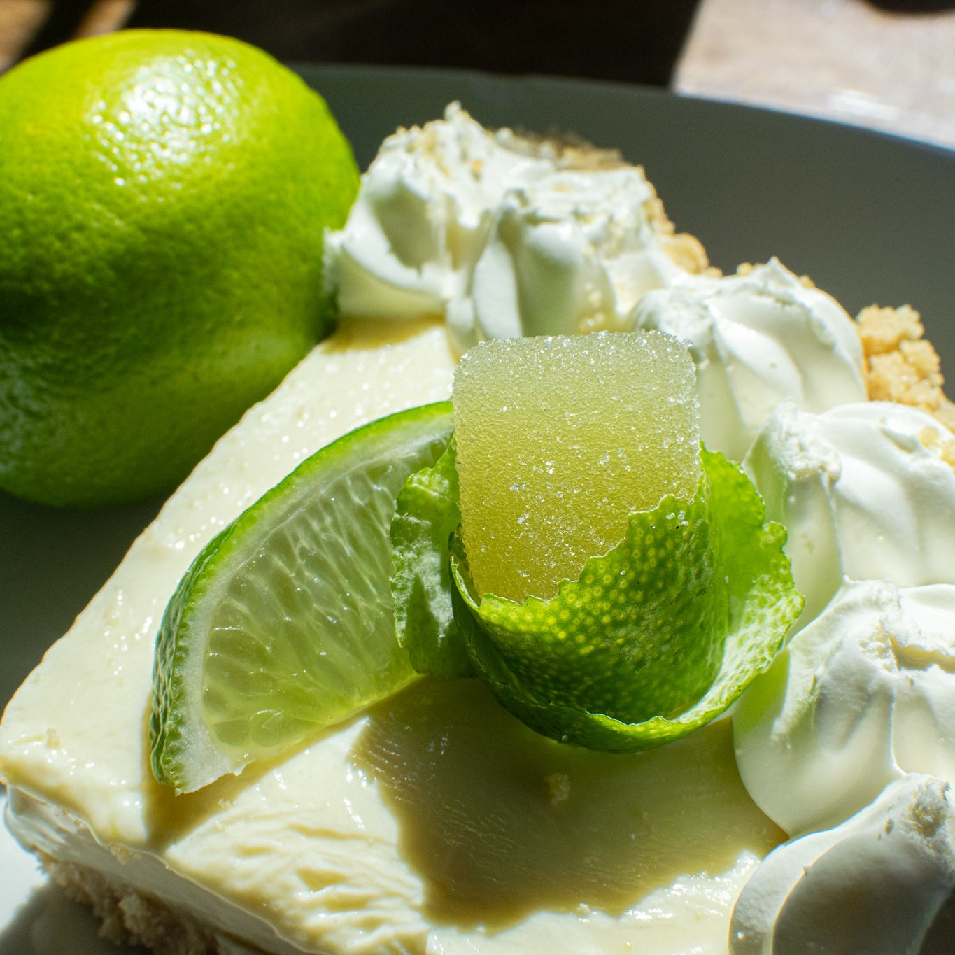 Key lime pie with whipped cream and lime slices on a plate