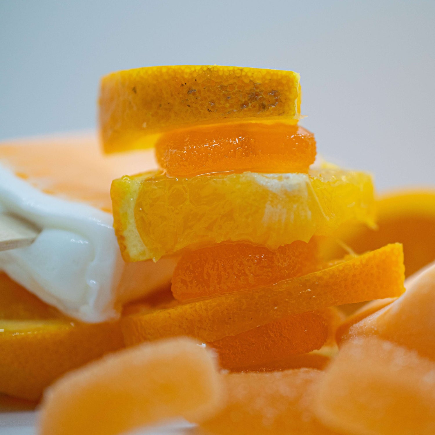 Close-up of sliced oranges and other citrus fruits on a white background